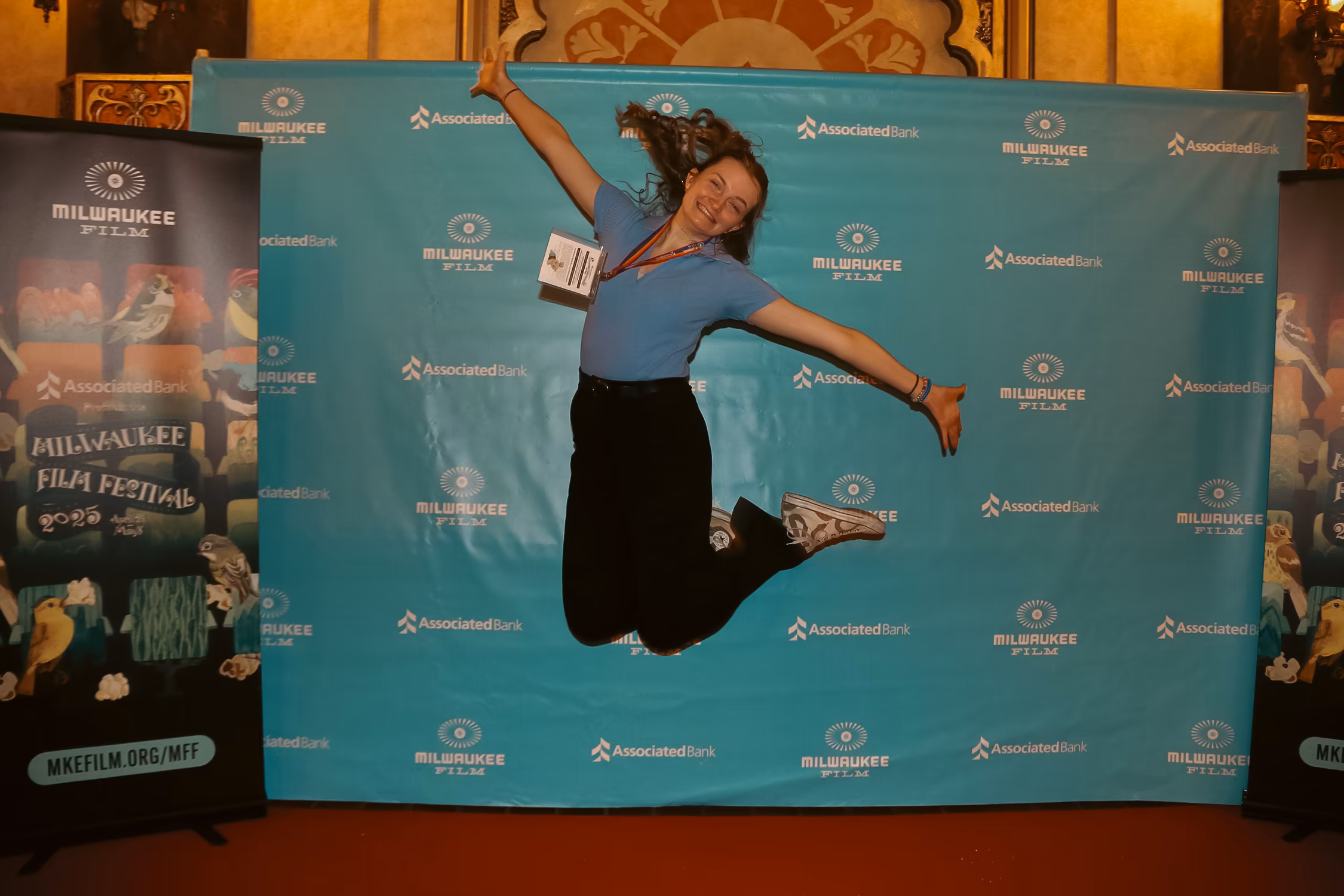 Staff Member Jumping for Joy in front of festival step and repeat Photo by Jolee Mallmann