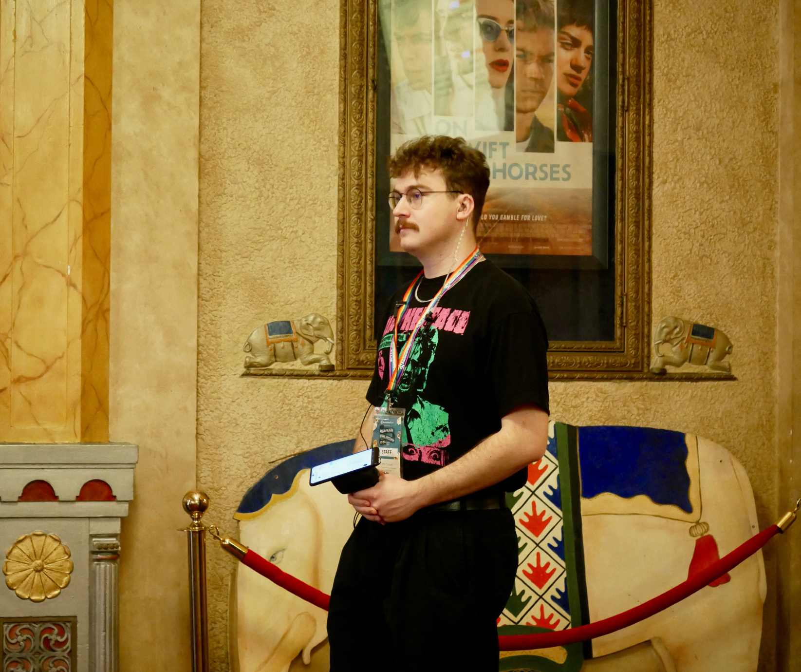 A staff member stands with a ticket scanner ready to admit patrons.