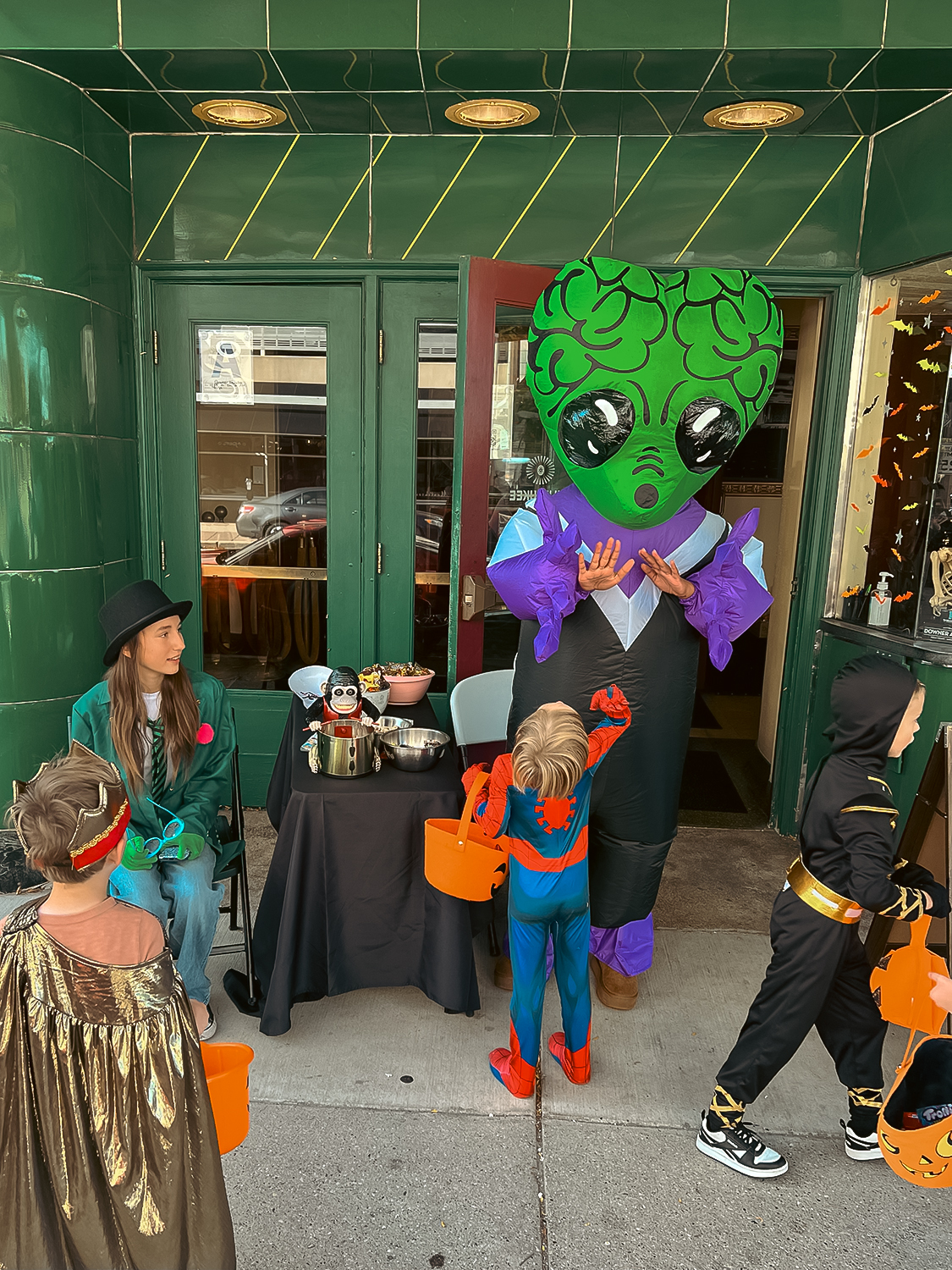 Kids in costume stand outside the Downer Theatre at Halloween.