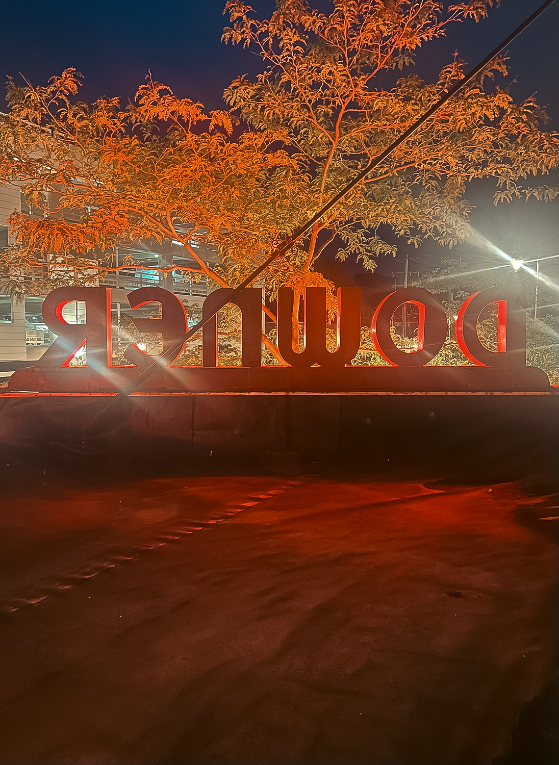 The Downer Theatre marquee sign shown from behind, backlit by streetlights.