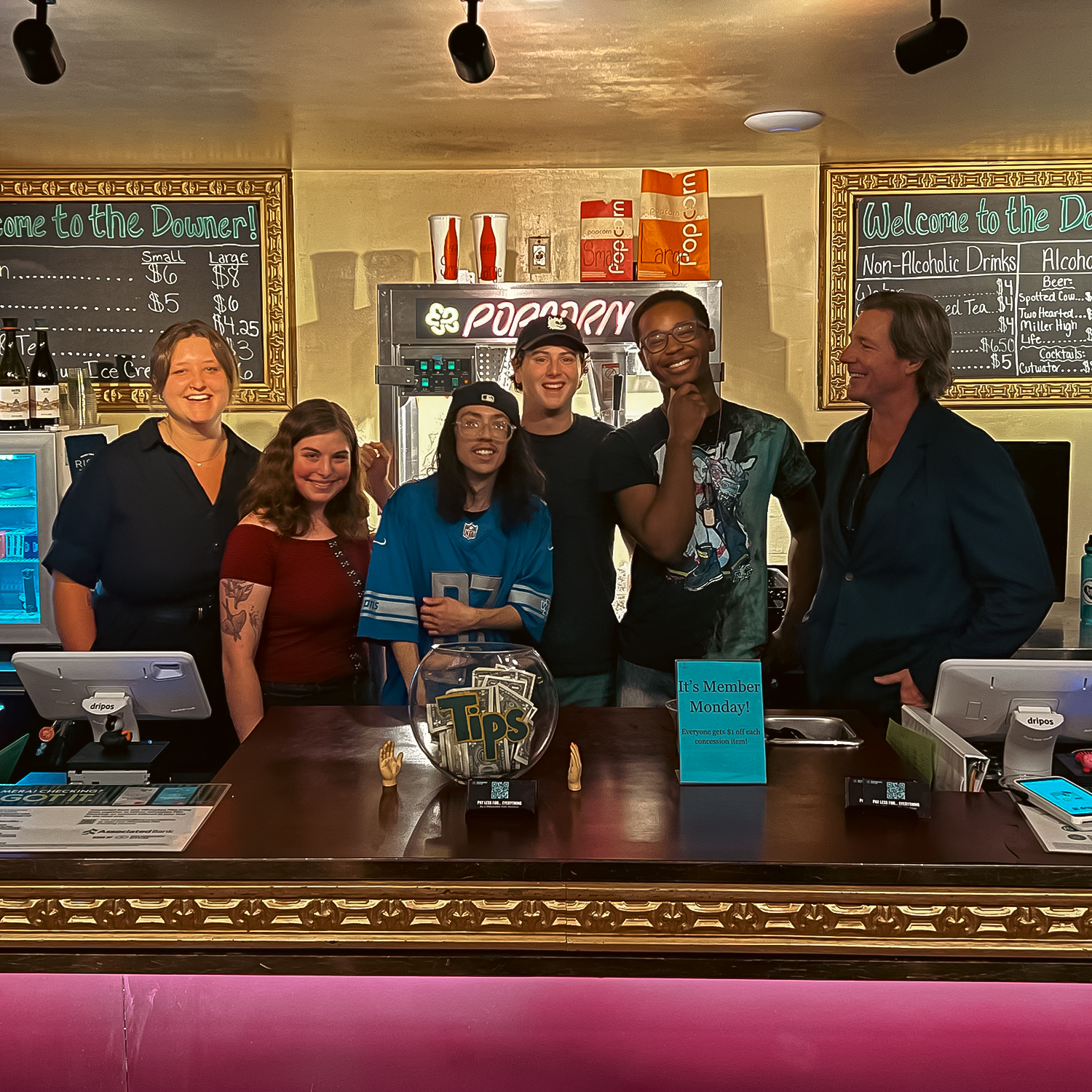 Staff members pose behind the concessions counter at the Downer Theatre.