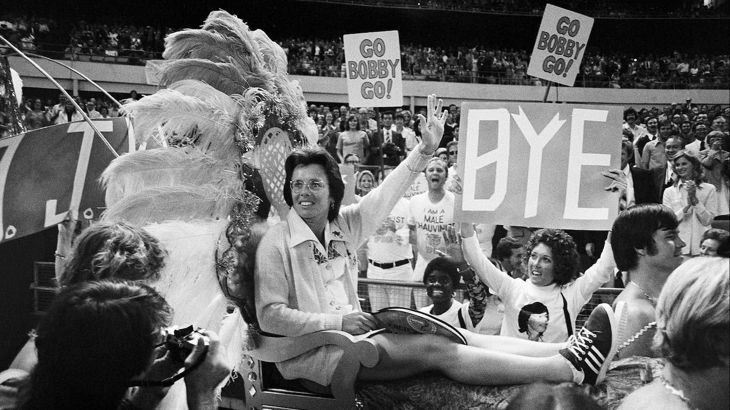 A still from the documentary GIVE ME THE BALL! featuring tennis player Billie Jean King participating in a parade