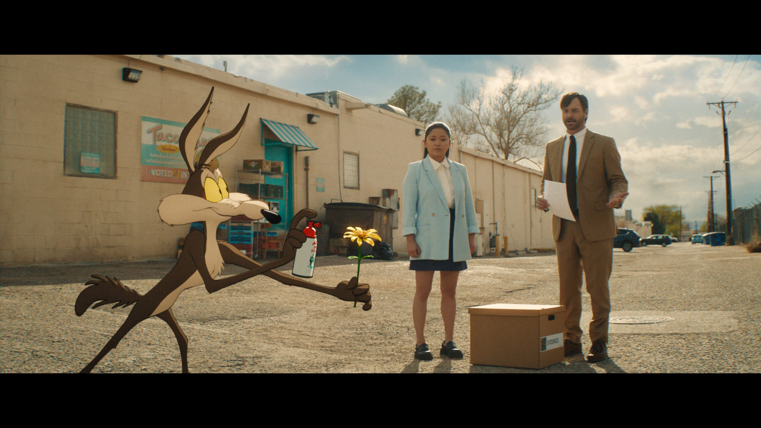 Coyote vs. Acme Film Still An animated Wile E. Coyote stands next two two humans, a man and a woman seemingly, in suits.
