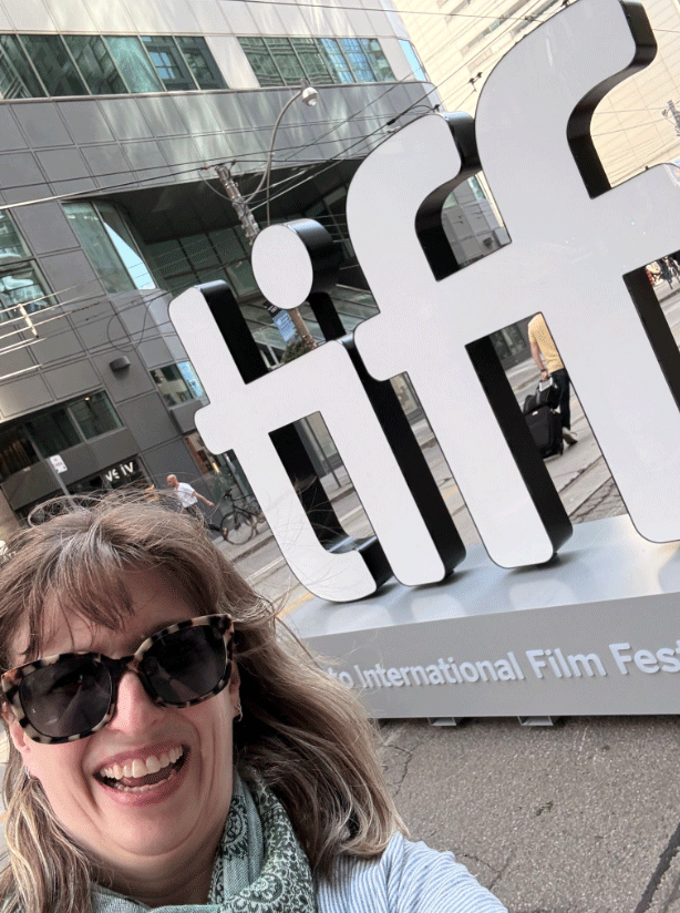 A photo of Artistic Director Cara in front of the sign for the Toronoto International FIlm Festival
